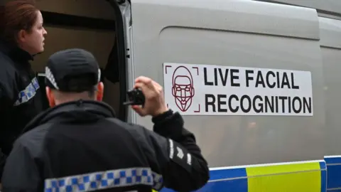 A picture of police officers include a live facial recognition van in Essex. 
