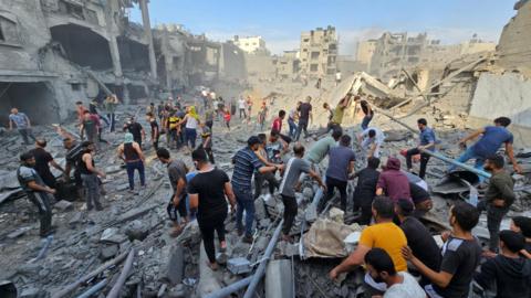 Palestinians search for survivors underneath the rubble of destroyed buildings in Jabalia refugee camp, in the northern Gaza Strip (31 October 2023)