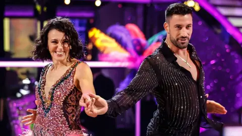 Amanda Abbington and Giovanni Pernice holding hands while dancing on Strictly