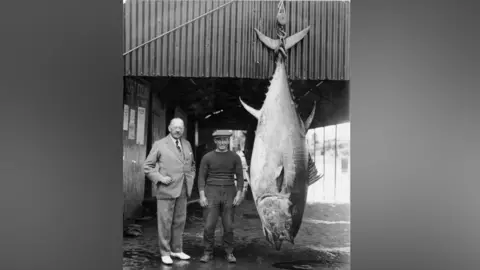 Whitby Museum A black and white photo of Lorenzo Mitchell-Henry with his record-breaking catch in Whitby.
