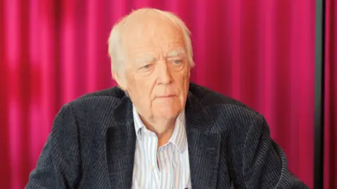 Close up shot of Sir Tim Rice wearing jacket and shirt