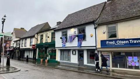 Shaun Whitmore/BBC Two people walking down street