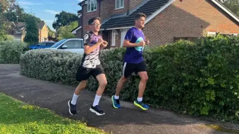 Family photo Zac and his dad James running along a residential street