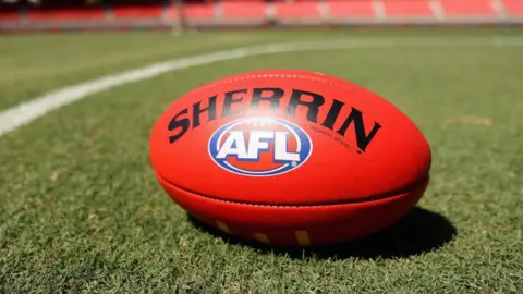 An Australian Rules Football ball on grass 