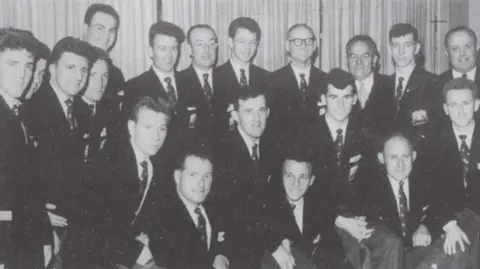 Glenavon FC A black and white image of the 1960 Glenavon FC Irish League championship winning squad. They are looking at the camera and are wearing black suits, white shirts and dark ties.