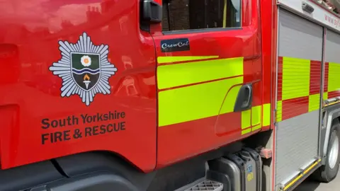 A red fire engine with the South Yorkshire Fire and Rescue logo on the side