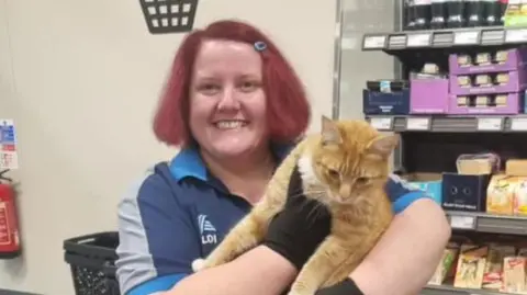 Lara Milne Raymond the cat with Lara Milne, who works in the local Aldi store