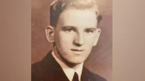 William Wake A black and white image of a very young William Wake. He is clean shaven, 18 years old and wearing a black jacket and tie.