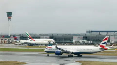 Getty Images Two British Airways and one Emirates planes on Heathrow Airport runway. 