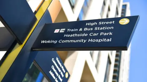 Signage in Woking, Surrey. The signs direct people to different places, including the High Street, train station and community hospital.
