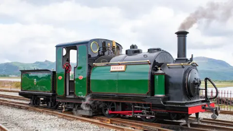 A green heritage engine with Prince nameplate on the rails in North Wales
