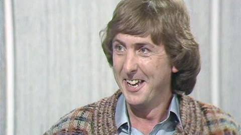 A close up of Eric Idle in the studio, speaking.