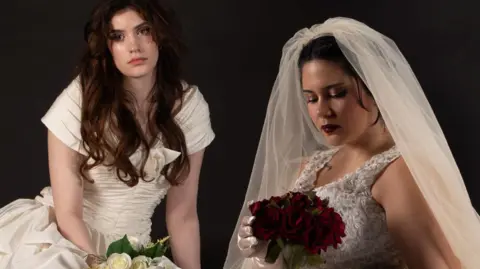 Two women modelling wedding dresses.