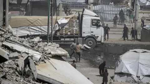 A humanitarian aid truck drives along Al Rashid road into Gaza City, 25 May 2025
