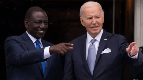 William Ruto and Joe Biden point to the crowd during an official White House event