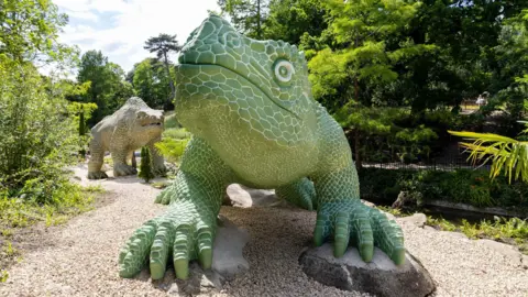 Crystal Palace Park Trust A big green dinosaur stands in front of a big brown dinosaur
