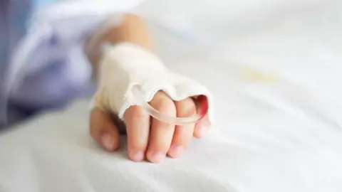 Child hand with tube and bandage