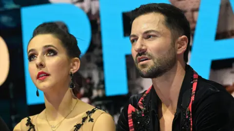 Lilah Fear and Lewis Gibson react as their results are revealed at the ice dance World Championships