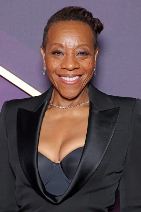 Getty Images Marianne Jean-Baptiste wearing a fitted all-black outfit with a bustier top underneath