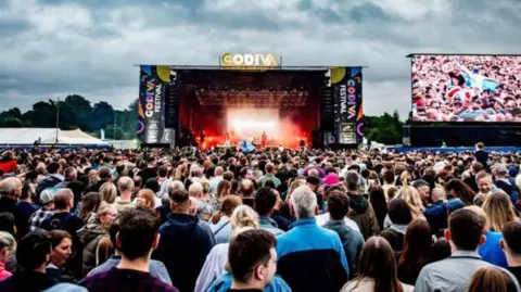 Picture of the main stage at Godiva festival where crowds of people gather.