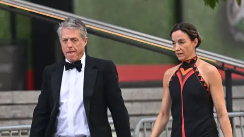 Hugh Grant arrives at Madison Square Garden with his partner.