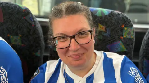 A fan on the coach back to Brighton in a blue and white kit