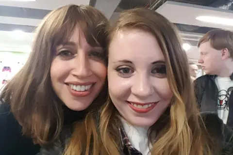 Amy Dyson Two women smile together in a selfie photograph taken of their faces