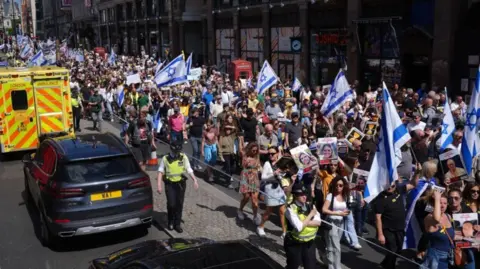 PA Media Thousands of people march with Israeli flags, placards and images of hostages