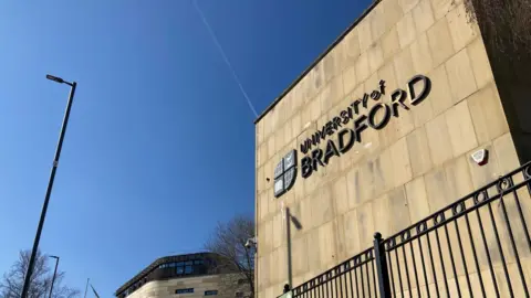 BBC A sign spelling out University of Bradford on the side of a stone-faced building