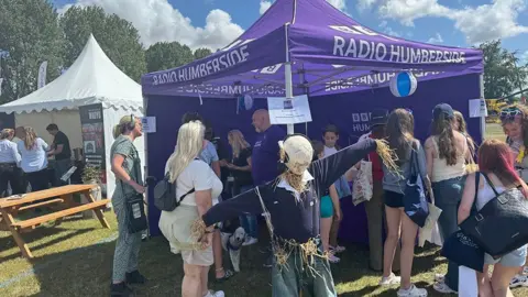 Dale Baxter / BBC The purple BBC Radio Humberside tent surrounded by visitors with a scarecrow in the foreground