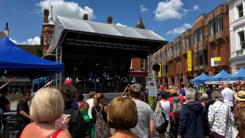 Spectators watch a steel band perform on a stage in Ipswich town centre. 