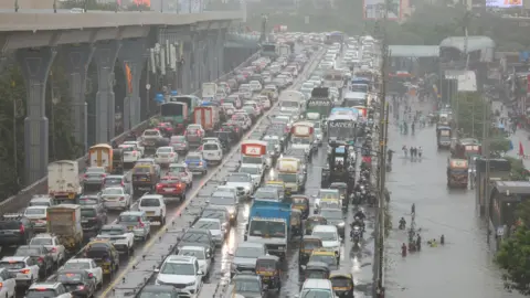 EPA/Shutterstock views of the congestion on the flooded street during heavy rains in Mumbai.