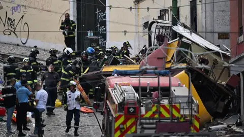 Rescuers and firefighters work at Getty Images at the scene after the Gloria Cable Cable railway in Lisbon, Portugal came out