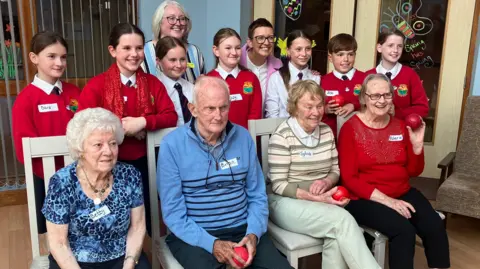 The residents and children pose for a photo together