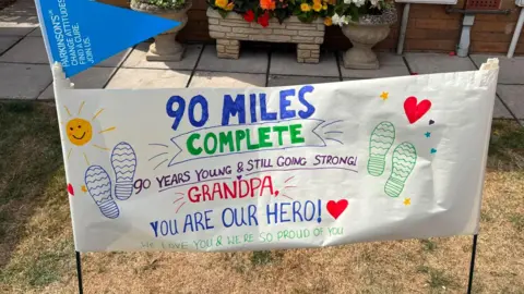 Imogen Treasure-Smith A banner saying 90 miles complete, 90 years and still going strong. Grandpa, you are our hero. 