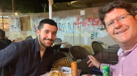 Samuel Edy and his father Angus pictured in a restaurant in Tel Aviv
