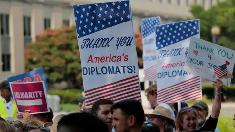 Getty Images People hold signs that read "thank you America's diplomats"