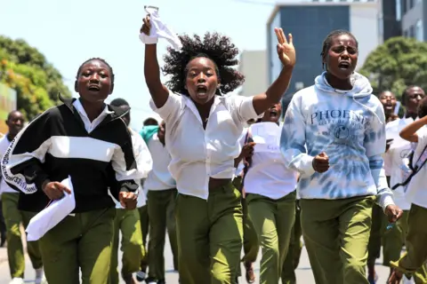 Luisa Nhantumbo/EPA-EFE Students march against the October election results as they return home from their final secondary school exams, in Maputo, Mozambique