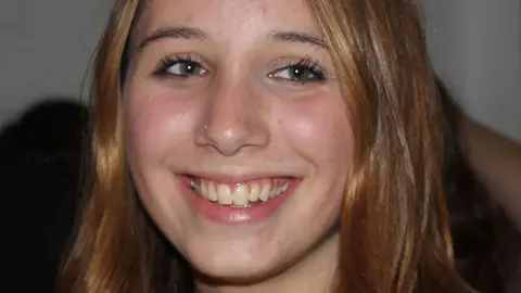 Alice Figueiredo close-up on face. She smiles and looks slightly off-camera