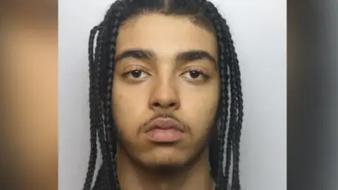 Thames Valley Police Jack Patterson - has dreadlocked, dark hair and a black moustache 