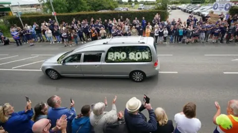 PA The funeral cortege passing through the streets