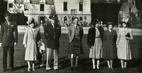 Getty Images 'Guests at Balmoral', October 1946. King George VI and Queen Elizabeth with daughters Princess Elizabeth (future Queen Elizabeth II) and Princess Margaret Rose, pose for a portrait with their guests General of the Army Eisenhower and his wife and son. 