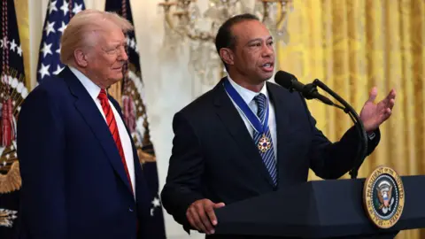 Getty Images Donald Trump stands behind Tiger Woods as he delivers remarks at a golf-themed reception in the White House