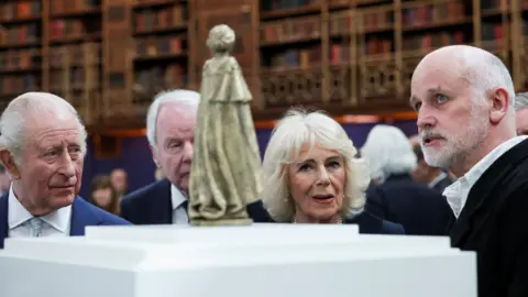Getty Images Sculptor Martin Jennings, on the right, shows his scaled model of the official national memorial statue of Queen Elizabeth to King Charles and Queen Camilla.