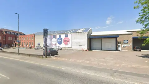 Google Maps The site from the road as it is now, showing an industrial building that is modern and looks a bit like an industrial estate.