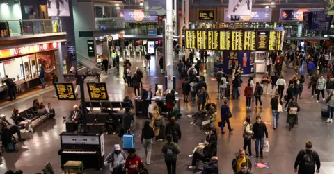 ADAM VAUGHAN/EPA-EFE/REX/Shutterstock Passengers wait on the concourse at Piccadilly station in Manchester