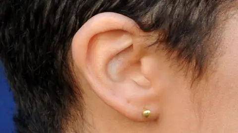 A picture of a woman's ear side on. 