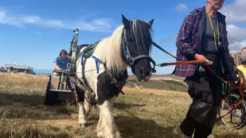 George Carden/BBC OBama the pony being led by Simon Mulholland and dragging along the cart which has 3 wheels. The pony is attached by two metal bars which are electro magnetic and clip to his harness