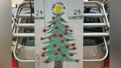 Mary-Ann Deasy Image of a christmas tree with 24 doors and 24 charities written on either side of it.