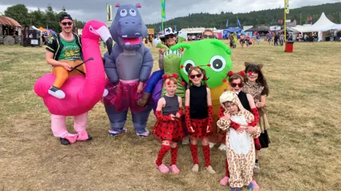 BBC The families are dressed in blow-up animal costumes and polka dot dresses and animal print onsies. 